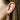 Close-up of an ear wearing a decorative earring with a blurred background