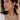 Woman wearing pearl earrings and a necklace, with a blurred background