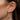 Close-up of an ear with gold earrings and piercings