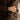 Person wearing a brown sweater with bracelets on a blurred background
